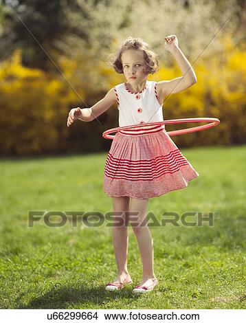 Young girl using hula hoop in a park View Large Photo Image Picture - Young girl using hula hoop in a park. Fotosearch