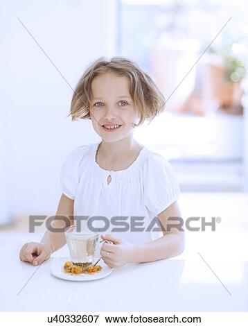 Young girl with cup of tea and flowers View Large Photo Image Stock Photo - Young girl with cup of tea and flowers. Fotosearch