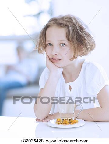 Stock Photo - Young girl with cup of tea and flowers. Fotosearch