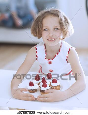 Young girl with plate of cupcakes View Large Photo Image Stock Photo - Young girl with plate of cupcakes. Fotosearch