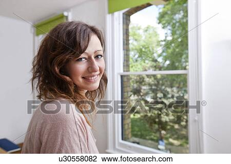 Young woman in trendy office looking at camera and smiling View Large Photo Image Stock Image - Young woman in trendy office looking at camera and smiling. Fotosearch