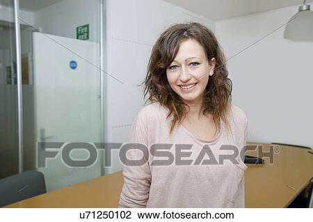 Young woman leaning against meeting table View Large Photo Image Stock Image - Young woman leaning against meeting table. Fotosearch