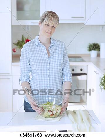 Stock Photo - Young woman making salad. Fotosearch