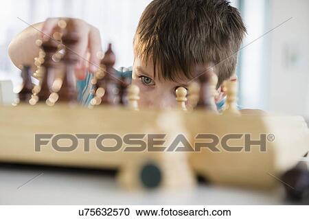 Boy (4-5) playing chess View Large Photo Image Stock Image - Boy (4-5) playing chess. Fotosearch