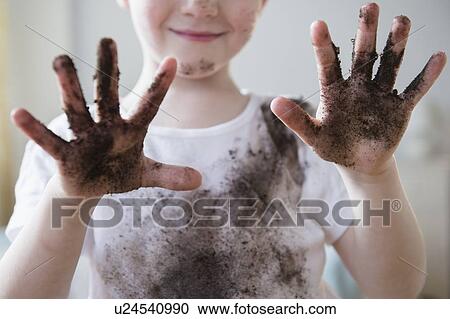 Stock Image - Boy (4-5) showing dirty hands. Fotosearch