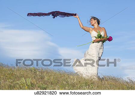 Bride standing in meadow View Large Photo Image Stock Image - Bride standing in meadow. Fotosearch