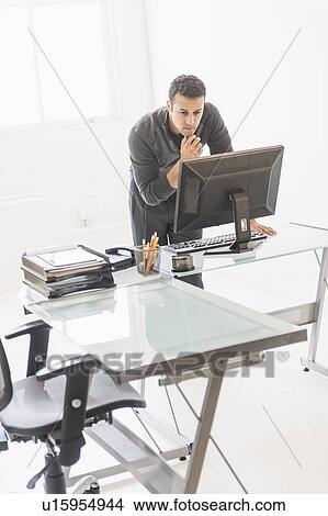 Businessman working at desk View Large Photo Image Picture - Businessman working at desk. Fotosearch