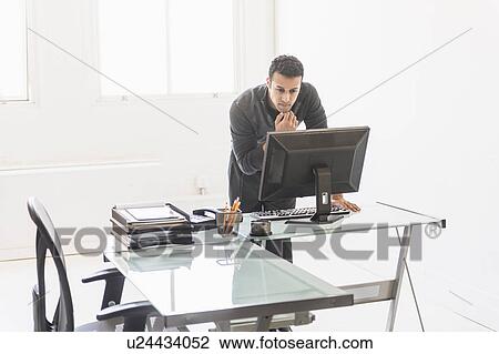 Businessman working at desk View Large Photo Image Stock Image - Businessman working at desk. Fotosearch