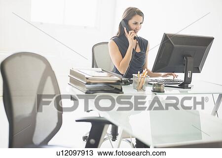 Businesswoman working at desk View Large Photo Image Stock Image - Businesswoman working at desk. Fotosearch