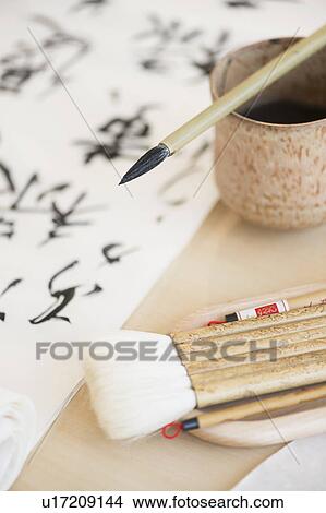 Picture - Calligraphy paintbrushes, ink and Japanese script. Fotosearch
