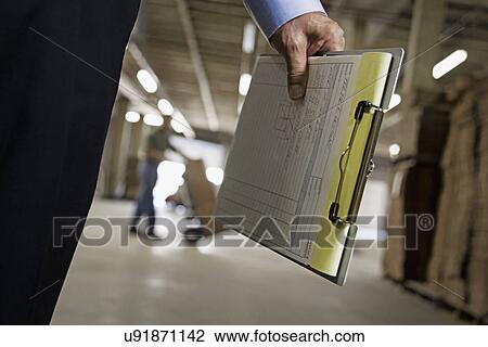 Close up of man holding clipboard in warehouse View Large Photo Image Stock Image - Close up of man holding clipboard in warehouse. Fotosearch