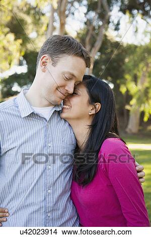 Picture - Couple embracing in park. Fotosearch