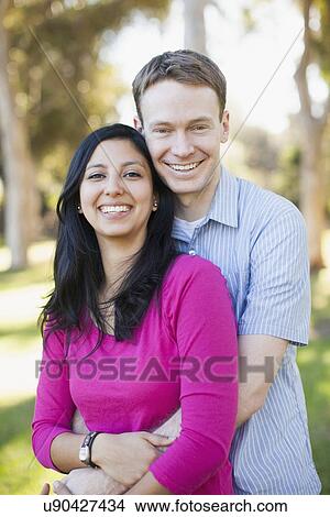 Picture - Couple embracing in park. Fotosearch