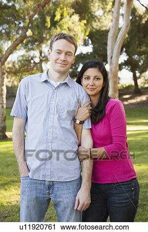 Stock Image - Couple embracing in park. Fotosearch