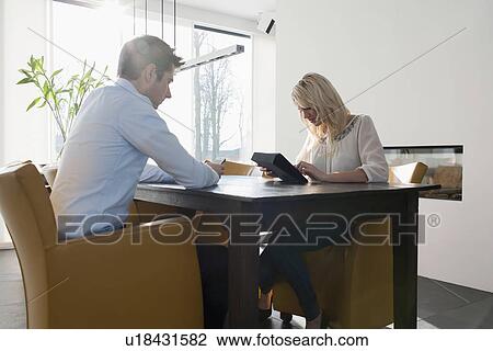 Couple sitting at table in morning View Large Photo Image Stock Image - Couple sitting at table in morning. Fotosearch