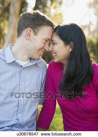 Couple sitting on grass in park View Large Photo Image Stock Photo - Couple sitting on grass in park. Fotosearch