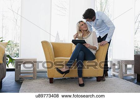 Stock Photo - Couple smiling to each other at home. Fotosearch