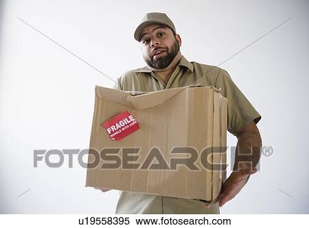 Delivery man holding damaged cardboard box View Large Photo Image Stock Photography - Delivery man holding damaged cardboard box. Fotosearch