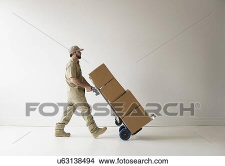 Delivery man walking with push cart View Large Photo Image Picture - Delivery man walking with push cart. Fotosearch