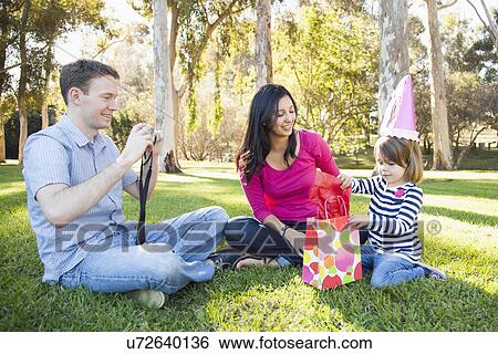 Stock Photograph - Family with daughter (4-5) playing in park. Fotosearch