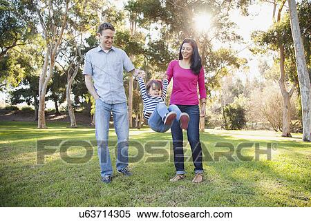 Family with daughter (4-5) playing in park View Large Photo Image Stock Photography - Family with daughter (4-5) playing in park. Fotosearch