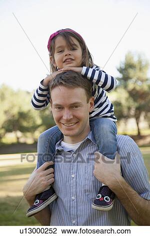 Father carrying his daughter (4-5 years) on holders View Large Photo Image Stock Image - Father carrying his daughter (4-5 years) on holders. Fotosearch