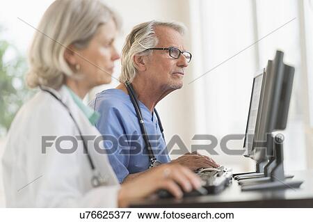Female and male doctors working at computers View Large Photo Image Stock Photo - Female and male doctors working at computers. Fotosearch