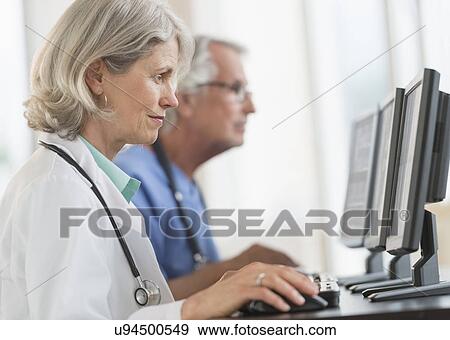Female and male doctors working at computers View Large Photo Image Stock Photo - Female and male doctors working at computers. Fotosearch