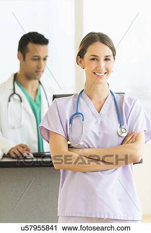 Stock Image - Female and male nurses at nurse's station in hospital. Fotosearch