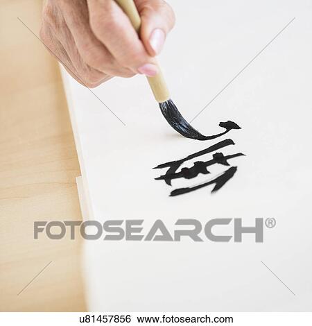 Stock Photograph - Female hand and japanese calligraphy. Fotosearch