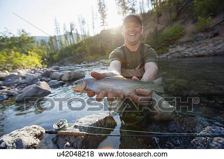 Fisherman showing fresh trout View Large Photo Image Stock Photo - Fisherman showing fresh trout. Fotosearch
