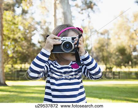 Girl (4-5) photographing in park View Large Photo Image Stock Image - Girl (4-5) photographing in park. Fotosearch