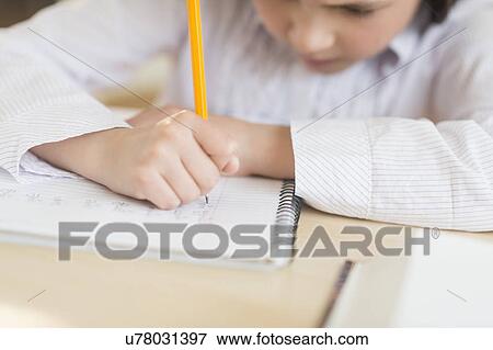 Stock Photo - Girl (8-9) doing homework. Fotosearch