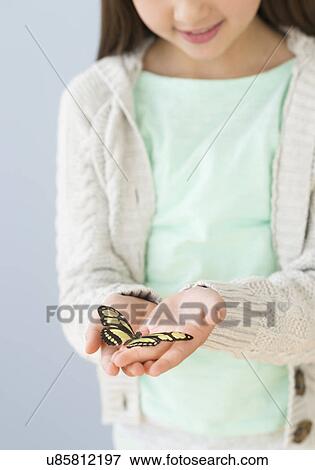 Girl (8-9) holding butterfly View Large Photo Image Stock Photo - Girl (8-9) holding butterfly. Fotosearch