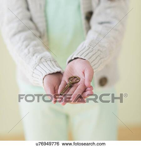 Stock Photograph - Girl (8-9) holding key. Fotosearch