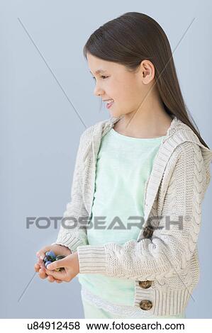 Girl (8-9) holding marbles View Large Photo Image Stock Photo - Girl (8-9) holding marbles. Fotosearch