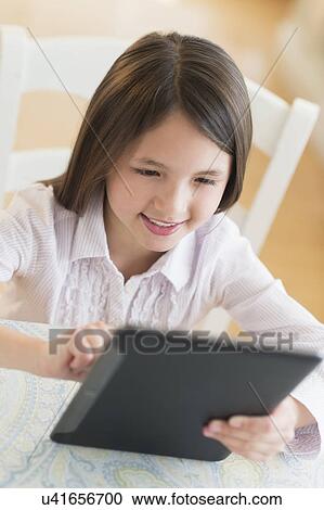 Girl (8-9) using digital tablet View Large Photo Image Stock Image - Girl (8-9) using digital tablet. Fotosearch