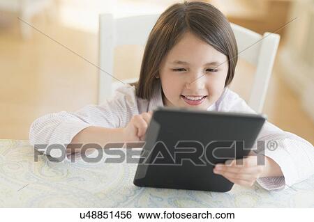 Girl (8-9) using digital tablet View Large Photo Image Stock Photograph - Girl (8-9) using digital tablet. Fotosearch