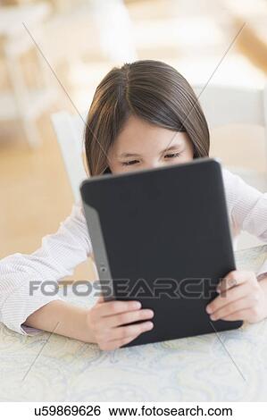 Girl (8-9) using digital tablet View Large Photo Image Stock Photograph - Girl (8-9) using digital tablet. Fotosearch