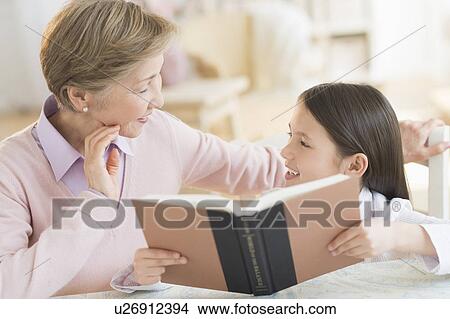 Granddaughter (8-9) and grandmother reading book View Large Photo Image Picture - Granddaughter (8-9) and grandmother reading book. Fotosearch