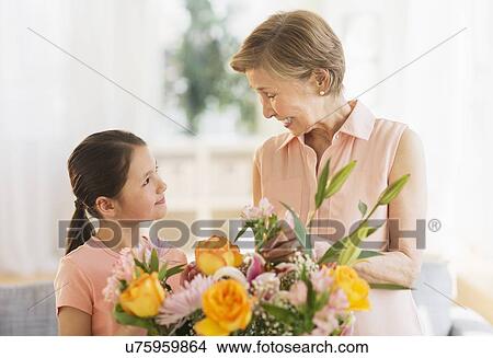 Granddaughter (8-9) and grandmother arranging flowers at home View Large Photo Image Picture - Granddaughter (8-9) and grandmother arranging flowers at home. Fotosearch