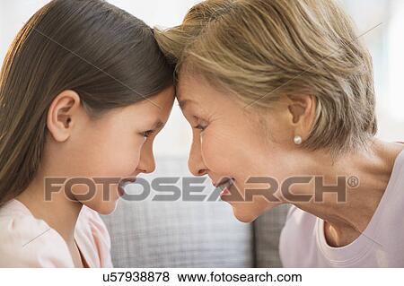 Granddaughter (8-9) and grandmother touching with heads View Large Photo Image Stock Photo - Granddaughter (8-9) and grandmother touching with heads. Fotosearch