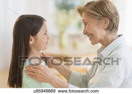 Granddaughter (8-9) and grandmother smiling to each other View Large Photo Image Stock Photo - Granddaughter (8-9) and grandmother smiling to each other. Fotosearch