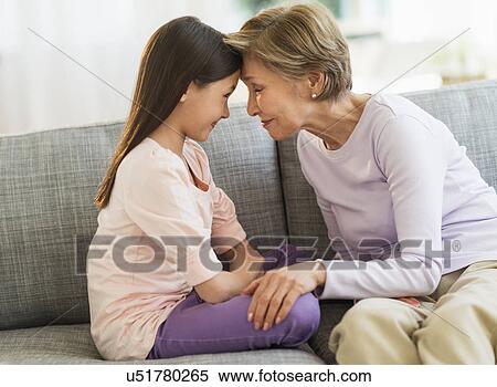 Granddaughter (8-9) and grandmother sitting on sofa and touching with heads View Large Photo Image Stock Photography - Granddaughter (8-9) and grandmother sitting on sofa and touching with heads. Fotosearch