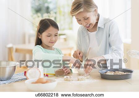 Granddaughter (8-9) cooking with grandmother View Large Photo Image Stock Photo - Granddaughter (8-9) cooking with grandmother. Fotosearch