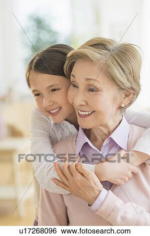 Granddaughter (8-9) embracing grandmother View Large Photo Image Stock Photograph - Granddaughter (8-9) embracing grandmother. Fotosearch