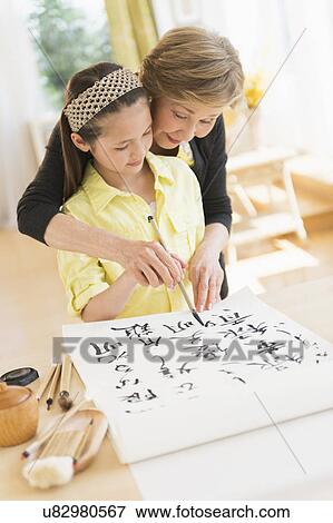 Grandmother and granddaughter (8-9) painting japanese symbols View Large Photo Image Stock Photo - Grandmother and granddaughter (8-9) painting japanese symbols. Fotosearch