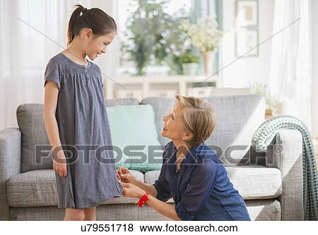 Grandmother attaching sewing pins to granddaughter's (8-9) dress View Large Photo Image Stock Photo - Grandmother attaching sewing pins to granddaughter's (8-9) dress. Fotosearch