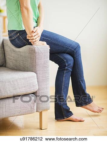 Low section of woman sitting on sofa View Large Photo Image Stock Image - Low section of woman sitting on sofa. Fotosearch