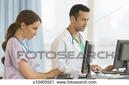 Male and female nurses working at nurse's station in hospital View Large Photo Image Stock Image - Male and female nurses working at nurse's station in hospital. Fotosearch